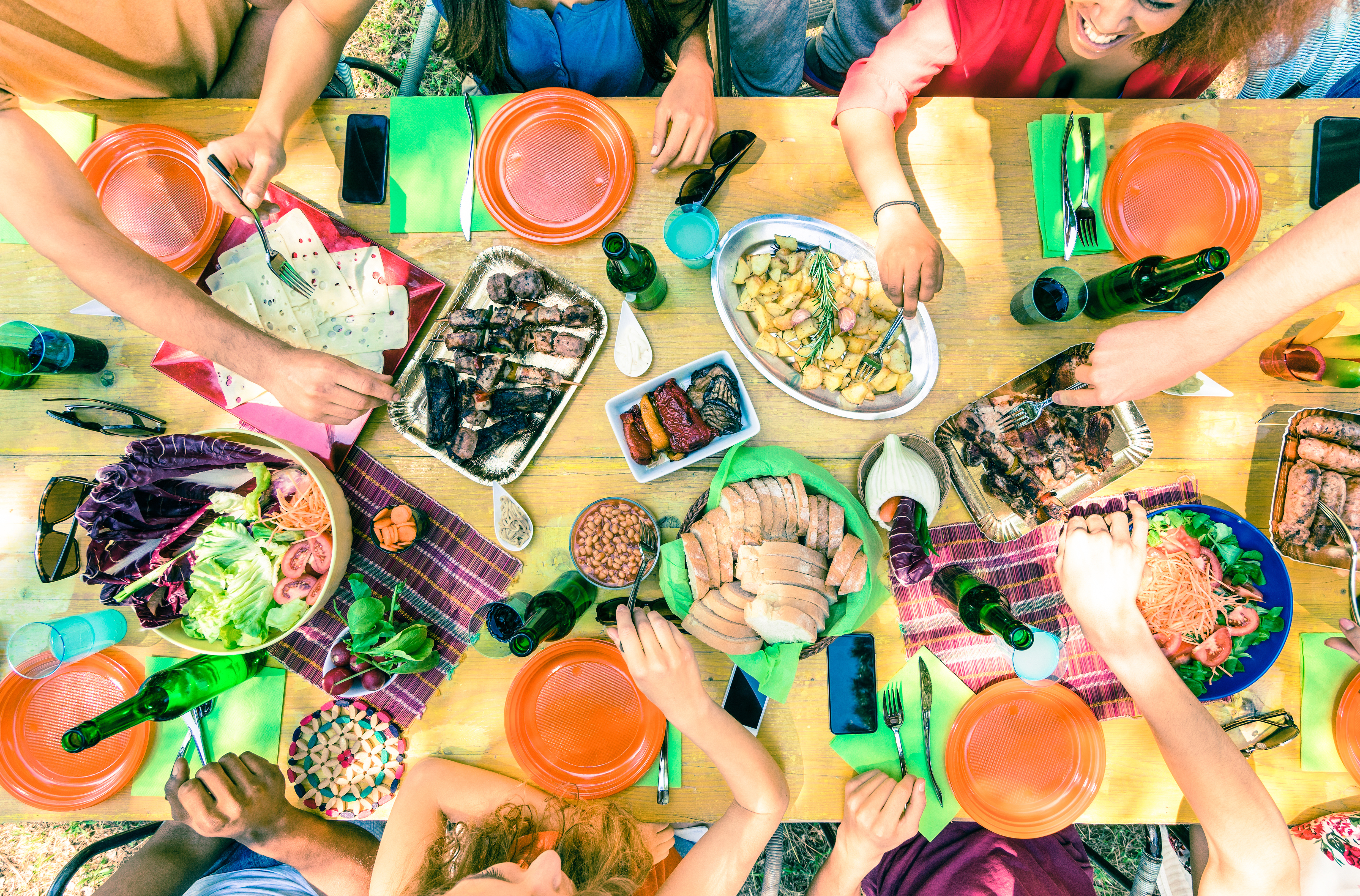 Top view of friend hands serving food at barbecue garden party - Multiracial people group enjoying grill meal at backyard bbq meeting - Lunch and dinner concept outdoors - Vivid cross processed filter